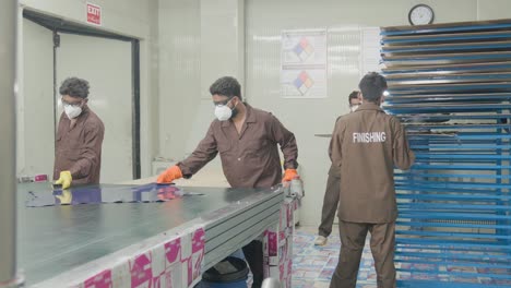 leather manufacturing workers processing tanned animal hides at a factory in pakistan.