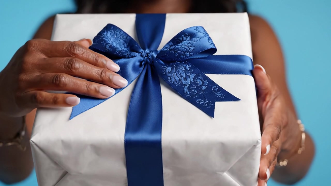 A beautifully wrapped gift box adorned with a blue ribbon, showcasing an elegant design that captures the excitement of giving and receiving presents.