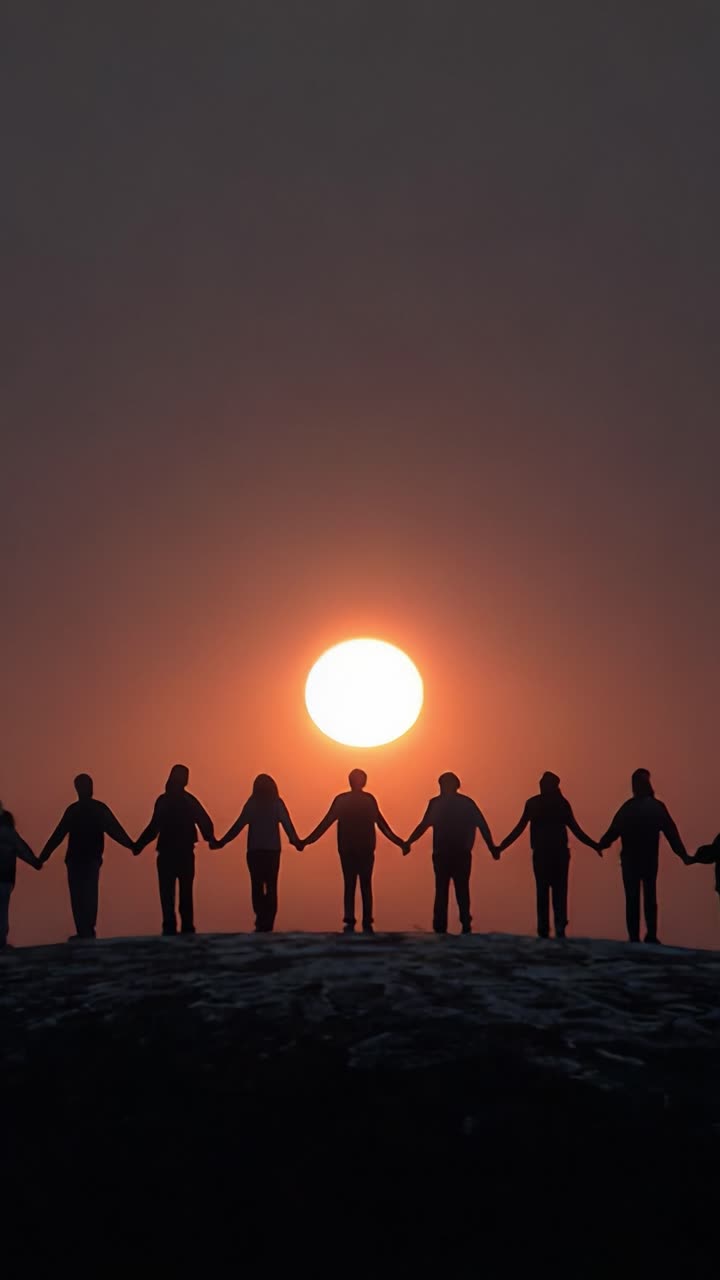A group of silhouettes holding hands against the backdrop of a stunning sunset, symbolizing unity, connection, and the beauty of shared experiences