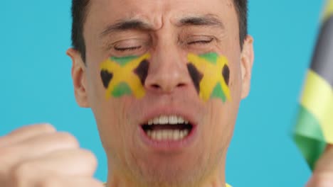 close up of a man supporting jamaican team