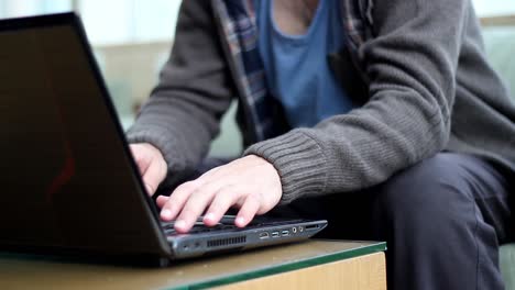 disparo de cerca de las manos del hombre trabajando en un teclado y ratón de computadora portátil