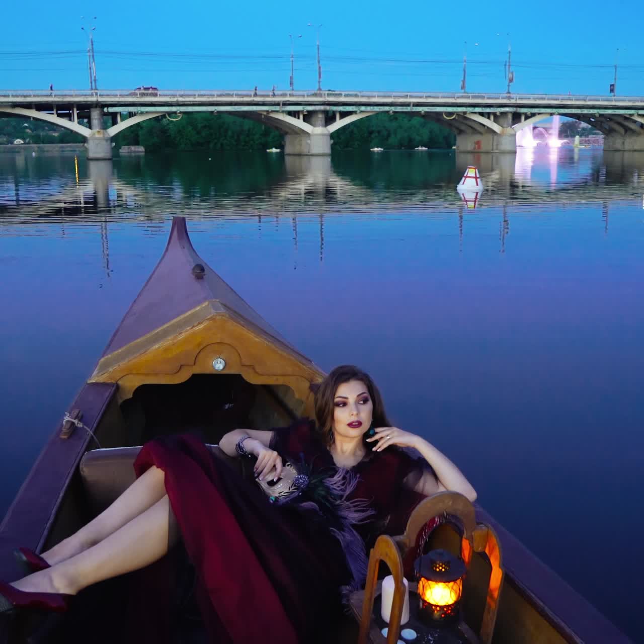 Beautiful woman in a boat. Gondola near the bridge at night.