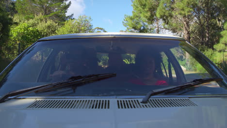 exterior view of friends in car enjoying summer road trip