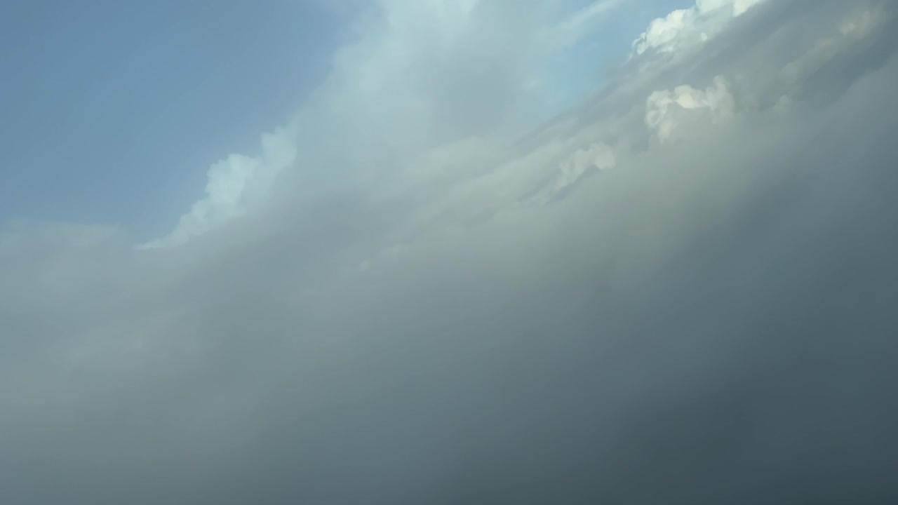 Unique aerial view pilot’s FPV of the silhouette (anthelion) of a jet airplane over the clouds when crossing them on a right turn descending. 4K