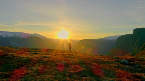 mysterious man walking towards sun on the mountain top