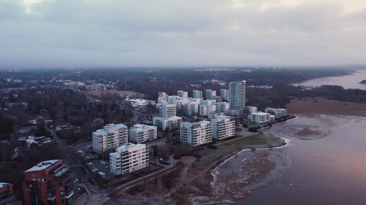 montón de bloques de apartamentos blancos junto al mar congelado en una noche nublada