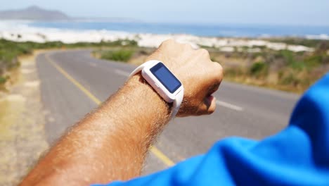 homem triatleta usando smartwatch em um dia ensolarado