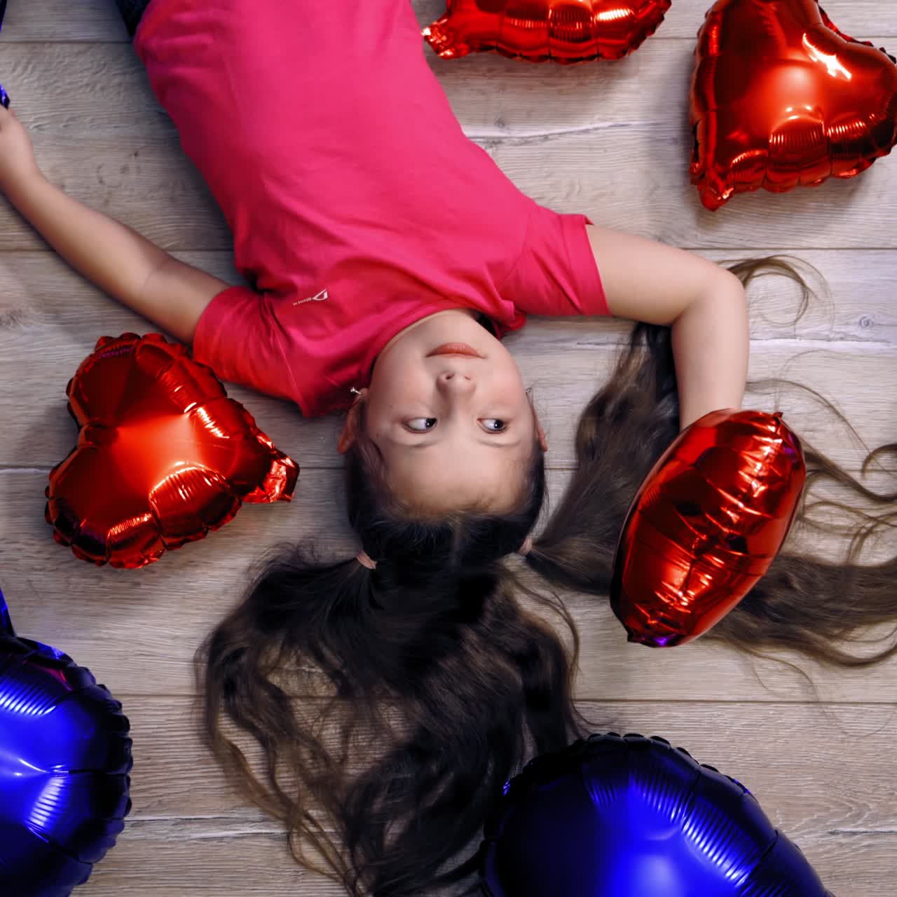 Cute girl lying on floor with balloons