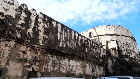 Pared-Exterior-Con-Almenas-Y-Pequeña-Torre-Del-Antiguo-Fuerte-De-Zanzíbar,-Ciudad-De-Piedra