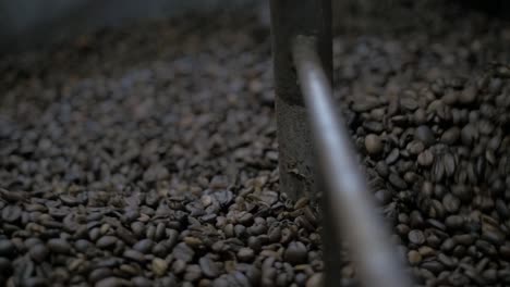 granos de café girando en el tostador, cierran a cámara lenta