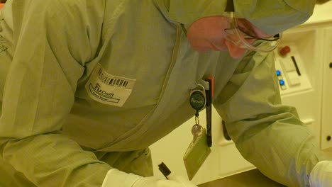 a scientist writing in the clean room about his current experiments or research.