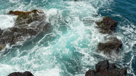 Foamy-Atlantic-ocean-water-flowing-over-rocky-coastline,-view-from-above