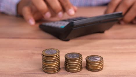 person calculating savings with coins