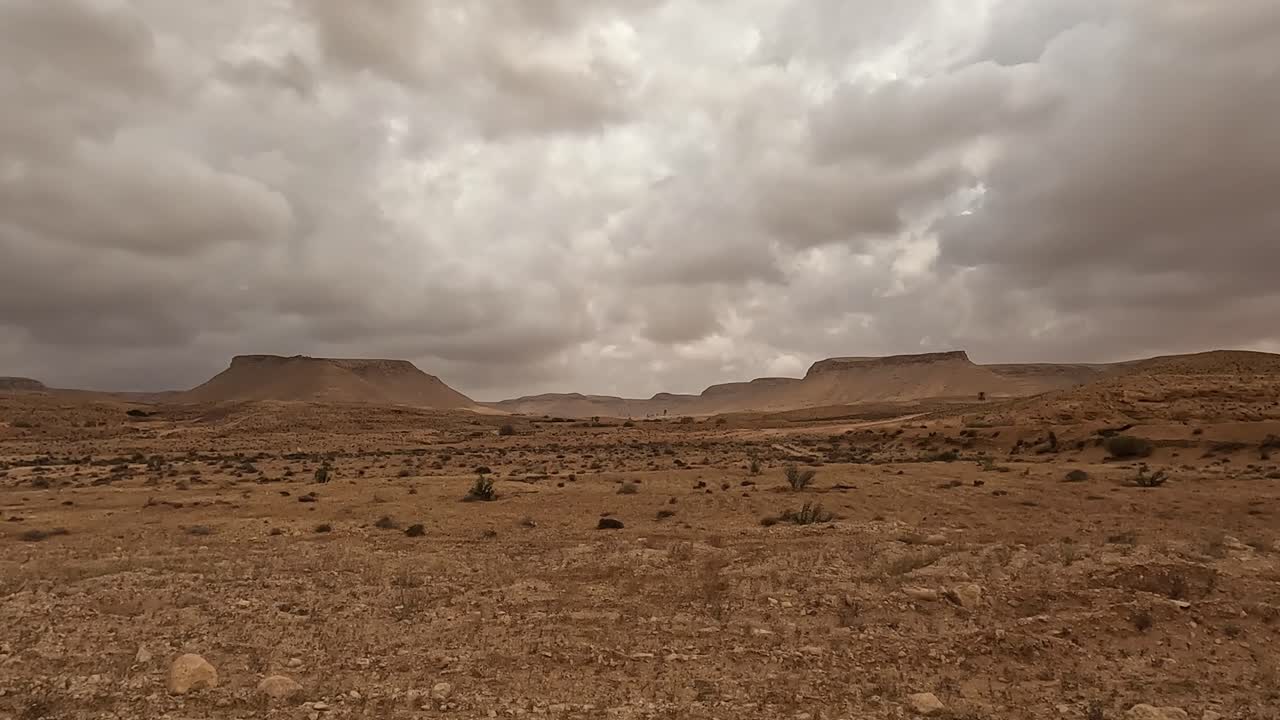 Rainy weather over Tunisia desert road, car driver POV