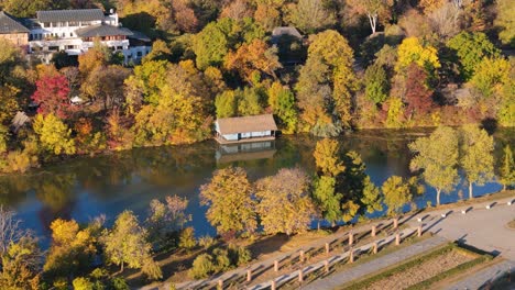 Rotierende-Drohnenansicht-Eines-Kleinen-Hauses-Am-Herastrau-See-In-Bukarest,-Rumänien,-Herbst