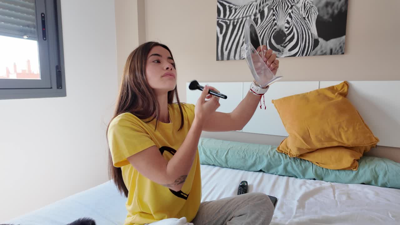 Woman applying makeup in her bedroom