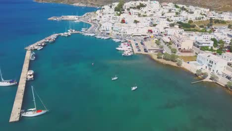 Aerial-view-to-Adamas-town,-the-port-of-Milos-island,-with-blue-sea-and-sailing-boats-and-yachts-in-the-marina,-Cyclades,-Greece