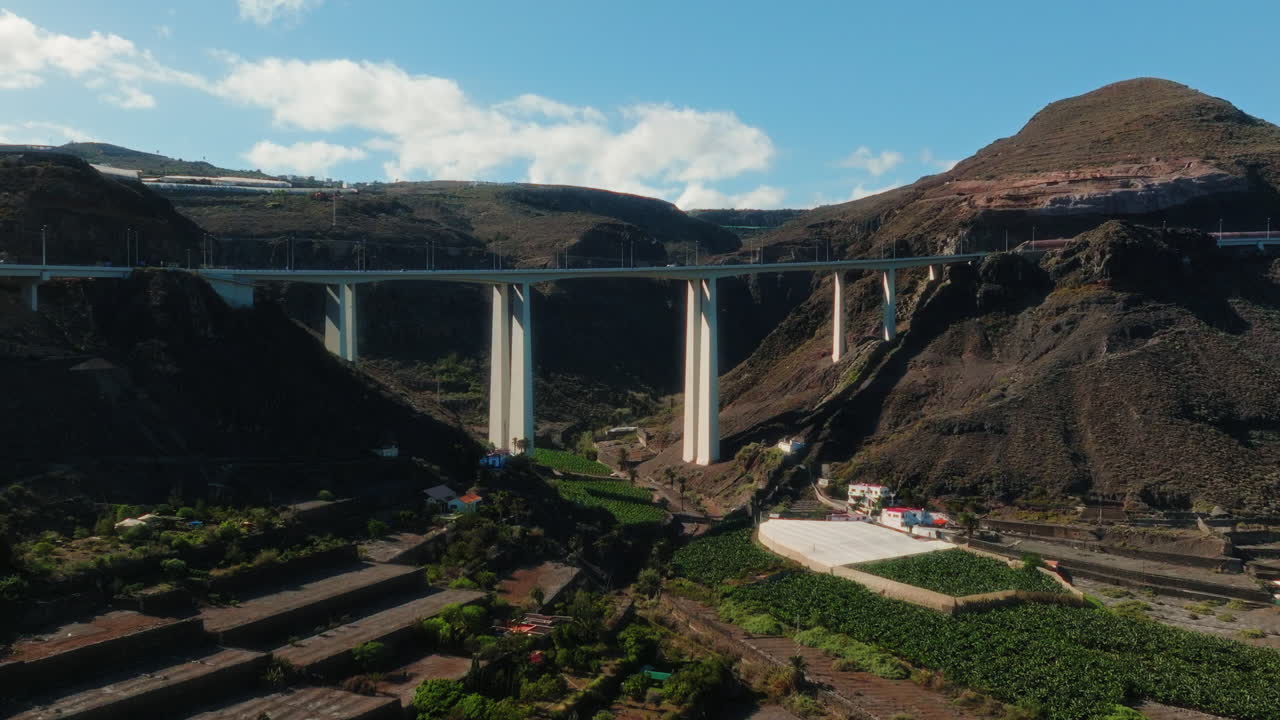 Establishing drone shot of white bridge in a valley during the day in Gran Canaria, Spain