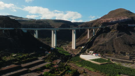 establishing drone shot of white bridge in a valley during the day in gran canaria, spain