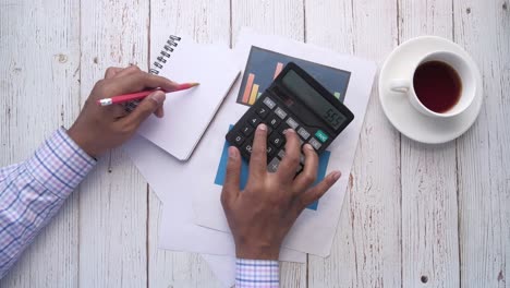 person working on calculations with calculator and notebook