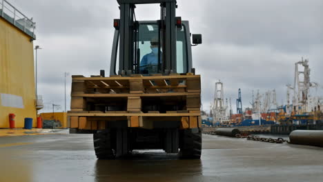 forklift transporting pallets on a wet port dock