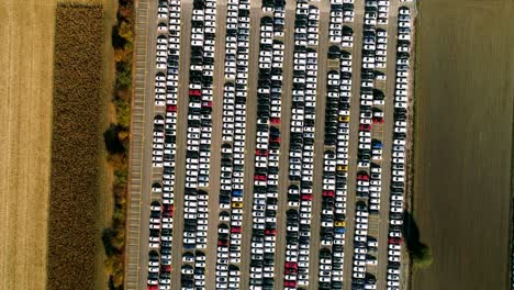 aerial footage of finished cars ready to be shipped on huge distribution center