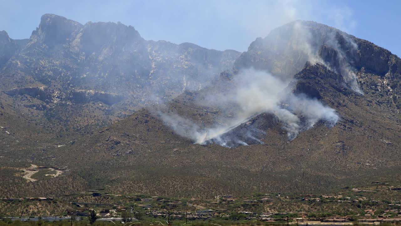 helicóptero del departamento de bomberos volando sobre el humo de los incendios forestales en la ladera de las montañas de santa catalina, al norte de tucson, arizona, ee.uu.