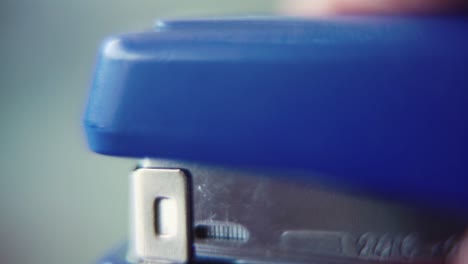 Macro-close-up-shot,-pressing-on-a-blue-stapler,-slow-motion-120-fps,-Full-HD-static-video