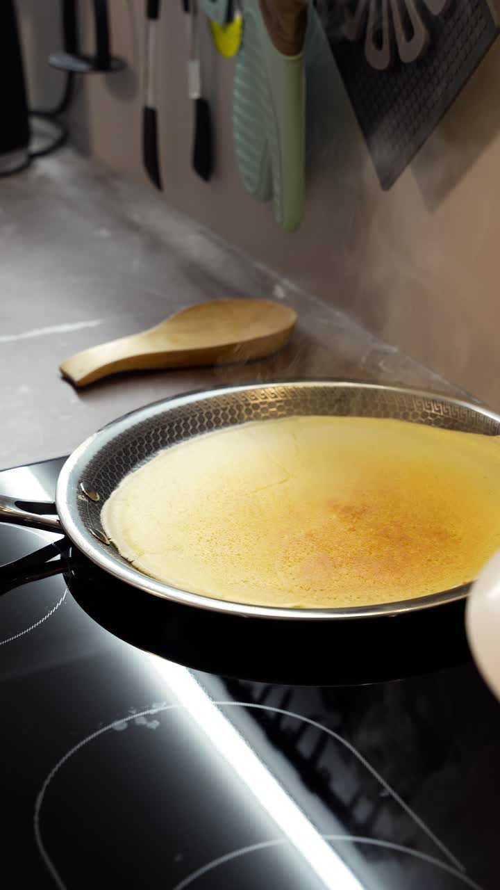 Steam rise from European-style pancake cooked in pancake frying pan. Vertical