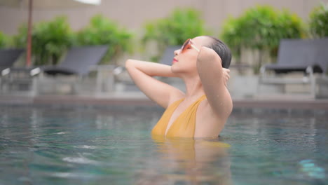 Sexy-exotic-woman-in-swimming-pool-with-sunglasses,-tropical-vacation-concept,-full-frame