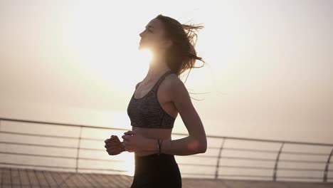 Junges-Sportliches-Mädchen,-Das-Auf-Einer-Promenade-Läuft.-Morgensonnenaufgang.-Küstenstraße.-Frei-Fühlen.-Gesunder-Lebensstil.-Schlanker-Körper