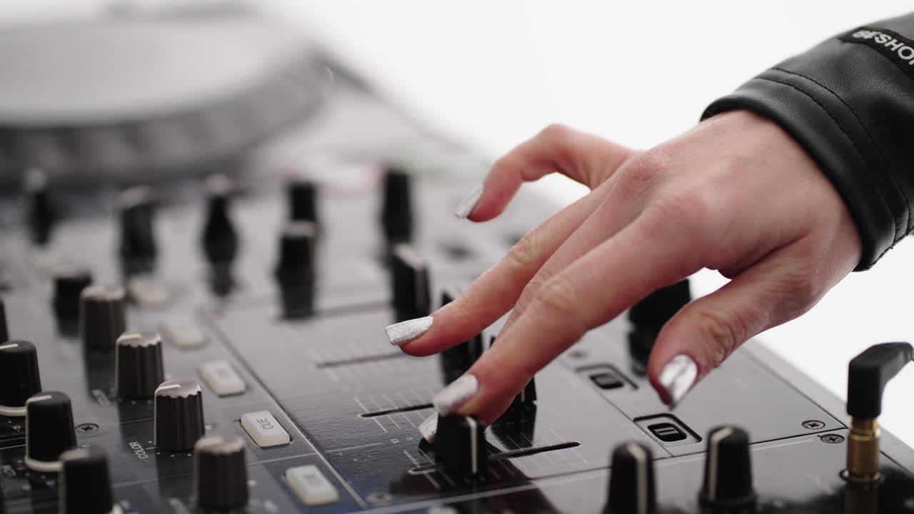 Close up of a female DJ mixing music on a mixer