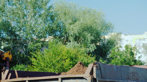 Excavator-Bucket-Pours-Ground-Into-The-Truck