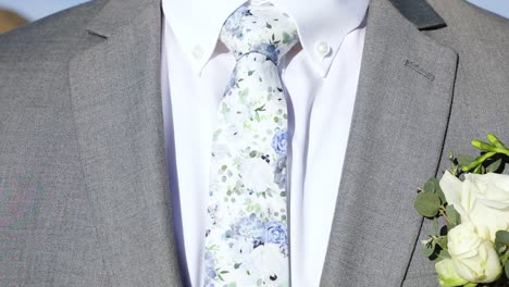 flor en el ojal fijada en la chaqueta de traje de novio con corbata floral