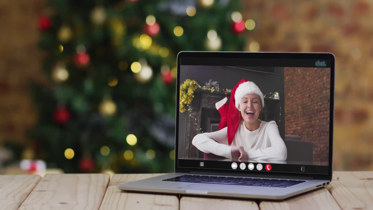 mujer caucásica feliz en videollamada en computadora portátil, con decoraciones de navidad y árbol