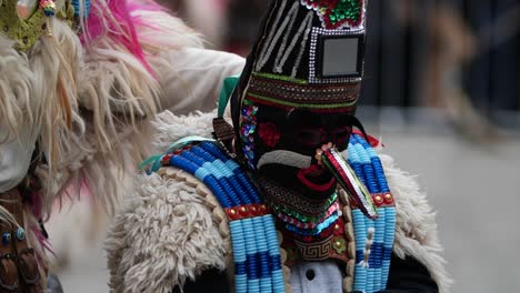 slow motion shof of kid kuker towards adult bulgarian kuker wearing costume decorated with wool and beads