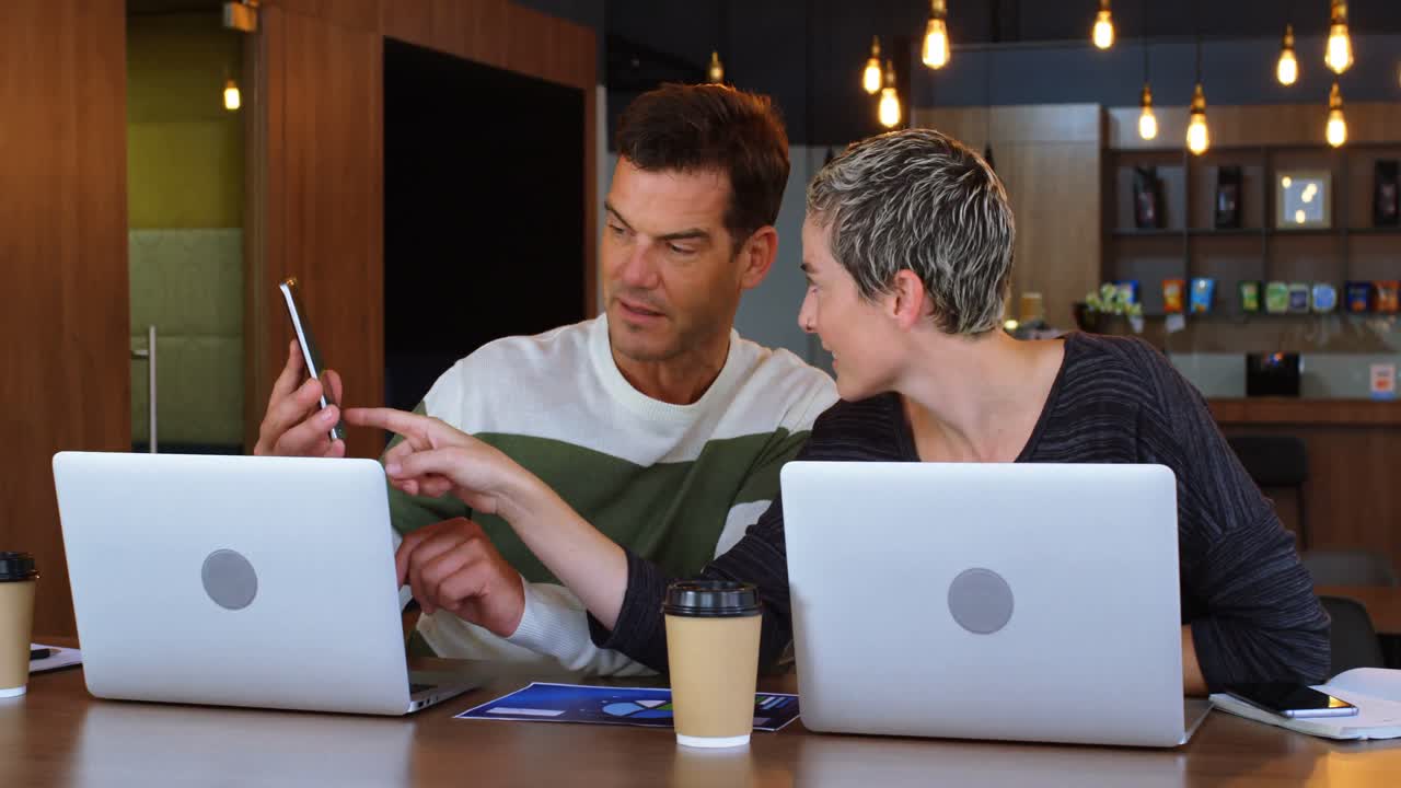 Executive discussing on mobile phone in office cafeteria 4k