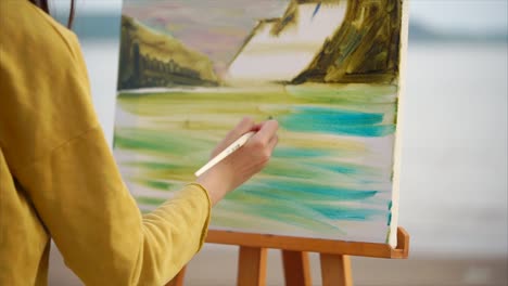woman painting a landscape at the beach