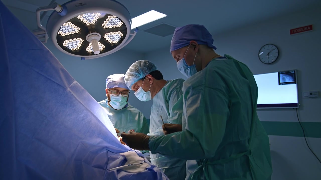 Equipe medica professionale che esegue un intervento chirurgico. Medici e assistenti uomini collaborano durante un'operazione per trauma.