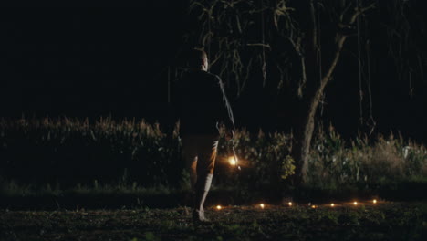 person with a lantern in a dark field at night