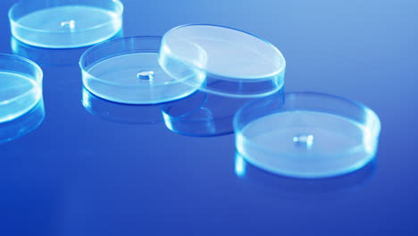 video of close up of laboratory round glass dishes with copy space on blue background