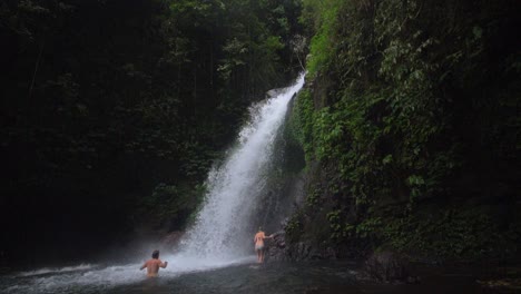 bathers under a waterfall