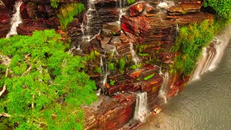 beautiful canyon cliff wall with streams of water flowing down as the camera tilts downwards