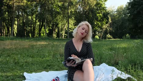 una chica en el parque se sienta y hojea una revista