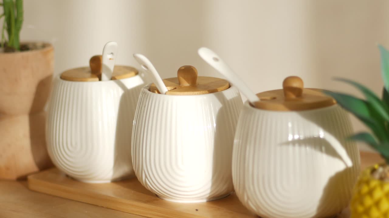 White Ceramic Spice Jars with Wooden Spoons on a Wooden Tray