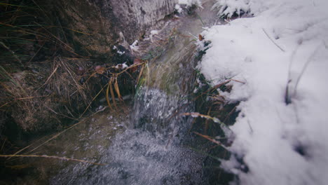 crystal clear water of stream rapid in pure snowy winter scenery