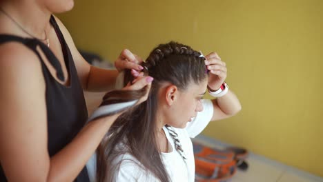 woman getting her hair braided by a hairstylist