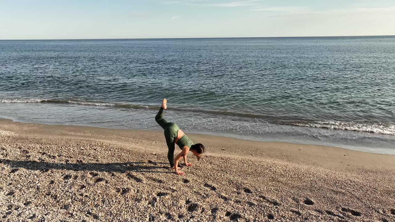 Young woman performing balancing yoga pose on the beach