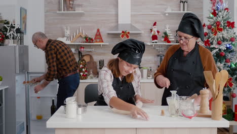 Grandparents-helping-granddaugher-preparing-traditional-homemade-dough