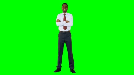 businessman standing with arms crossed against green background